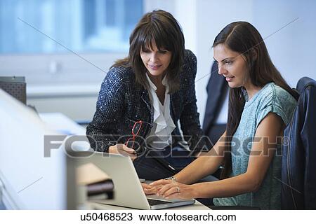 Businesswomen working on laptop View Large Photo Image Stock Image - Businesswomen working on laptop. Fotosearch