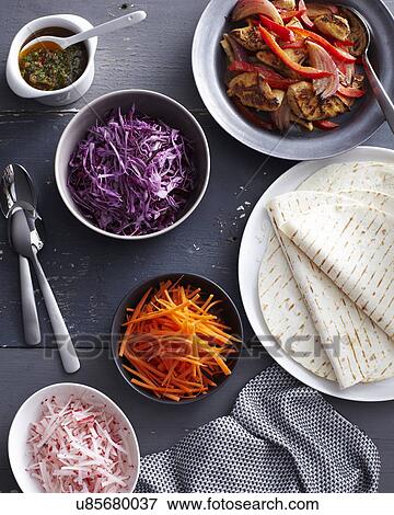 Stock Photo - Chilli chicken fajitas with fresh raw vegetables. Fotosearch