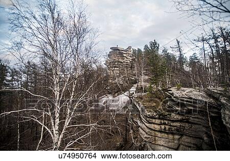 Climber on top of rock formation in mountain forest View Large Photo Image Picture - Climber on top of rock formation in mountain forest. Fotosearch
