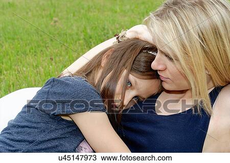 Close up of girl and mother hugging in park View Large Photo Image Stock Image - Close up of girl and mother hugging in park. Fotosearch