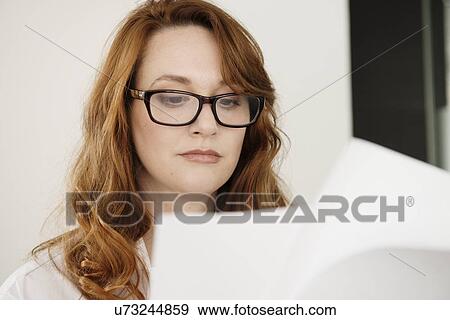 Close up of mid adult businesswoman reading paperwork View Large Photo Image Stock Photo - Close up of mid adult businesswoman reading paperwork. Fotosearch