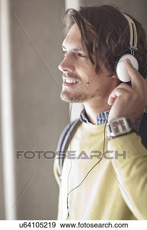 Close up of mid adult man listening to music on headphones View Large Photo Image Stock Photo - Close up of mid adult man listening to music on headphones. Fotosearch