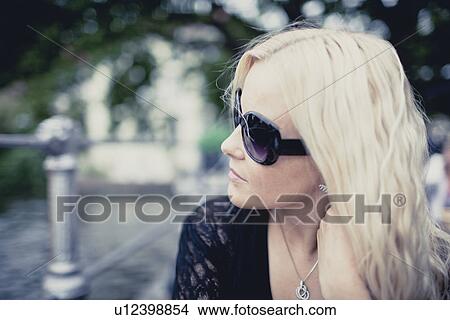 Close up of mid adult woman in park wearing sunglasses View Large Photo Image Picture - Close up of mid adult woman in park wearing sunglasses. Fotosearch
