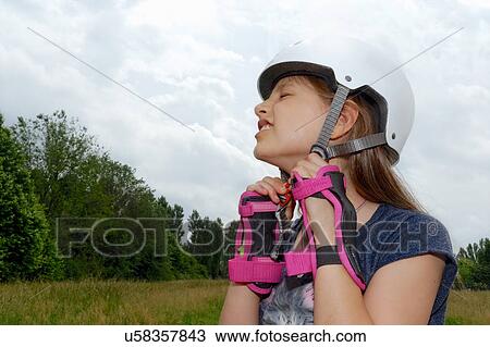 Close up of rollerblading girl struggling to fasten skate helmet View Large Photo Image Stock Image - Close up of rollerblading girl struggling to fasten skate helmet. Fotosearch
