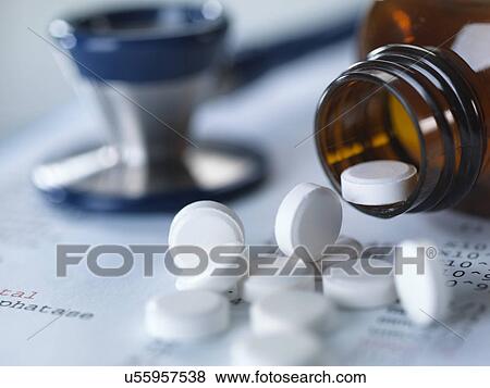 Stock Photo - Close up of stethoscope and pain killers pouring onto medical test results. Fotosearch