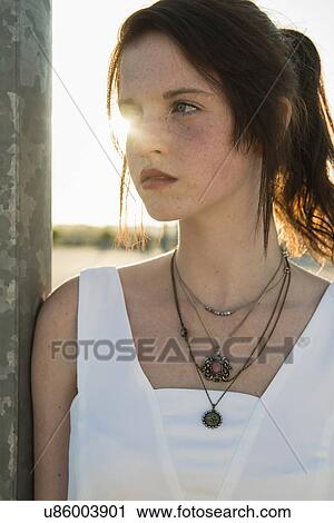 Close up portrait of serene young woman leaning against wall View Large Photo Image Stock Image - Close up portrait of serene young woman leaning against wall. Fotosearch
