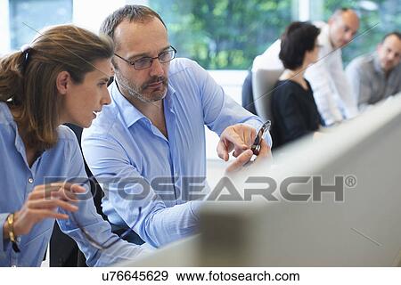 Colleagues looking at mobile phone View Large Photo Image Stock Photo - Colleagues looking at mobile phone. Fotosearch