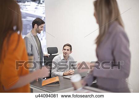 Colleagues talking in office View Large Photo Image Stock Image - Colleagues talking in office. Fotosearch