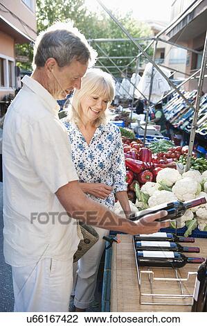 Couple choosing wine at market, Mallorca, Spain View Large Photo Image Stock Image - Couple choosing wine at market, Mallorca, Spain. Fotosearch