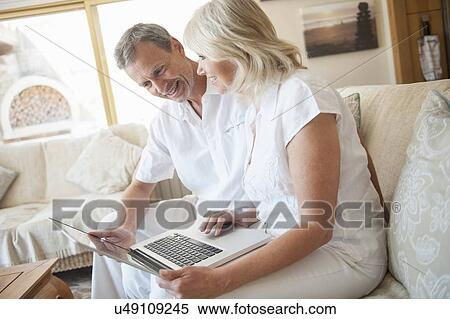 Stock Photography - Couple using laptop in hotel room. Fotosearch