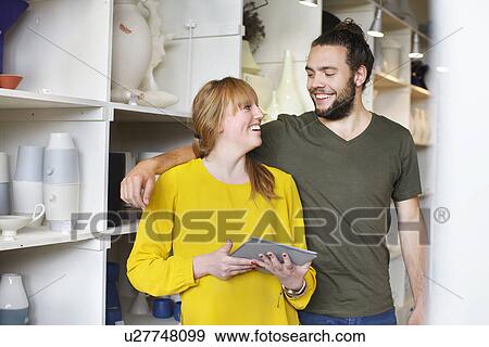 Stock Photo - Couple with digital tablet in ceramic workshop. Fotosearch