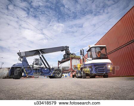 Crane stacking tank containers from truck in port View Large Photo Image Stock Photo - Crane stacking tank containers from truck in port. Fotosearch