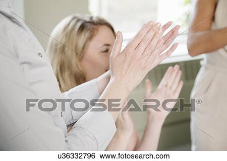 Stock Photograph - Cropped shot of three businesswomen applauding. Fotosearch