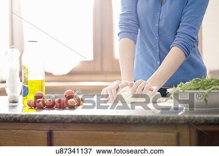 Cropped shot of young woman kneading pizza dough View Large Photo Image Stock Photo - Cropped shot of young woman kneading pizza dough. Fotosearch