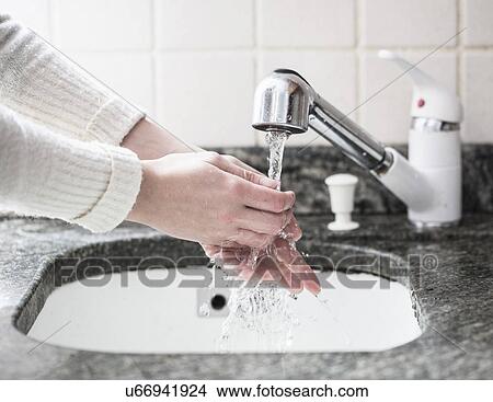 Cropped shot of young woman washing hands in sink View Large Photo Image Picture - Cropped shot of young woman washing hands in sink. Fotosearch
