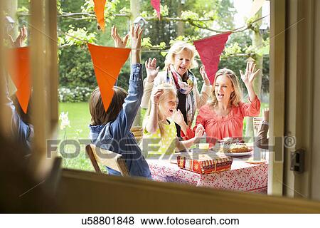Family singing and cheering at birthday party View Large Photo Image Stock Photo - Family singing and cheering at birthday party. Fotosearch