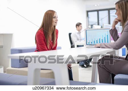 Female colleagues using laptop View Large Photo Image Picture - Female colleagues using laptop. Fotosearch