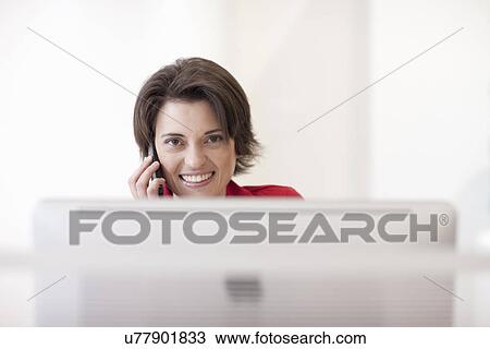 Female office worker on cell phone View Large Photo Image Stock Image - Female office worker on cell phone. Fotosearch