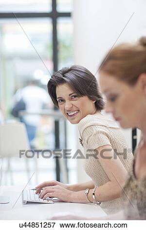 Female office worker using computer View Large Photo Image Stock Photo - Female office worker using computer. Fotosearch