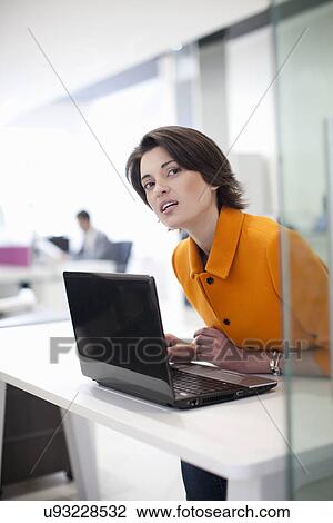 Female office worker using laptop, leaning forward View Large Photo Image Stock Image - Female office worker using laptop, leaning forward. Fotosearch