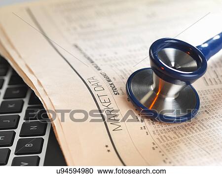 Stock Image - Financial health check: stethoscope on newspaper with financial markets for investing. Fotosearch