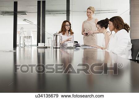 Four businesswomen meeting in conference room View Large Photo Image Stock Photo - Four businesswomen meeting in conference room. Fotosearch