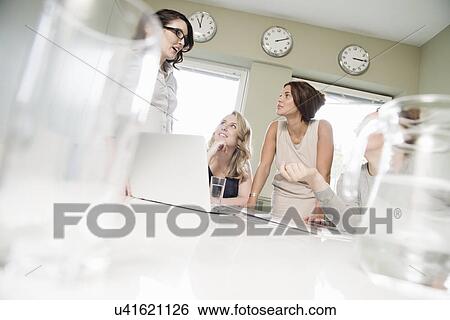 Four businesswomen meeting in conference room View Large Photo Image Stock Photograph - Four businesswomen meeting in conference room. Fotosearch