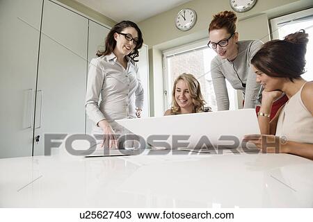 Four female designers looking at blueprint in office View Large Photo Image Stock Image - Four female designers looking at blueprint in office. Fotosearch
