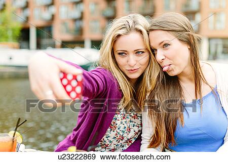 Stock Photo - Friends taking selfie by canal. Fotosearch
