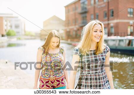 Stock Image - Friends walking by canal, Leeds, England. Fotosearch