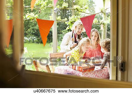 Girl blowing out birthday candles on her cake View Large Photo Image Stock Photography - Girl blowing out birthday candles on her cake. Fotosearch