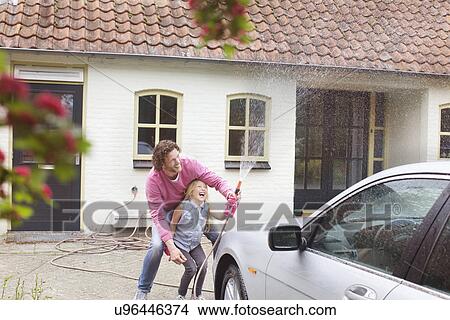 Picture - Girl helping father wash his car. Fotosearch