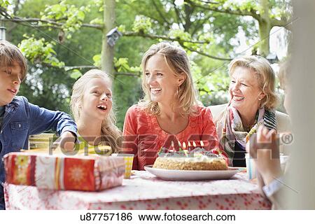 Girl making birthday wish with her family at birthday party View Large Photo Image Stock Photograph - Girl making birthday wish with her family at birthday party. Fotosearch