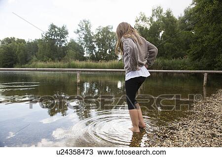 Girl paddling and looking down at lake View Large Photo Image Stock Image - Girl paddling and looking down at lake. Fotosearch