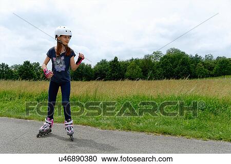 Stock Image - Girl rollerblading in park. Fotosearch