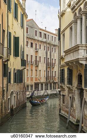 Stock Photo - Gondolier on narrow canal, Venice, Veneto, Italy. Fotosearch