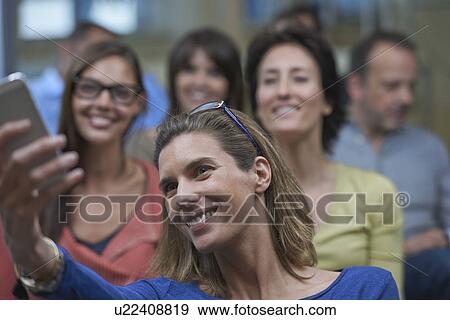 Stock Photo - Group of people taking self portrait photograph. Fotosearch