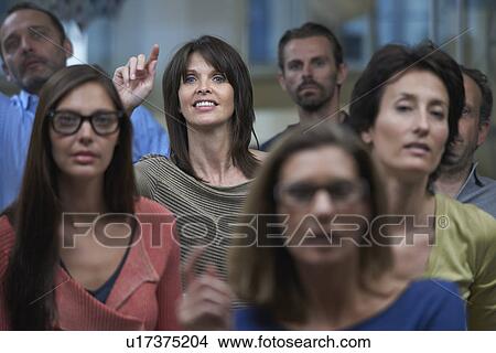 Group watching presentation, woman raising hand View Large Photo Image Picture - Group watching presentation, woman raising hand. Fotosearch