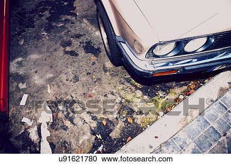 Stock Image - High angle cropped image of car parked next to kerb. Fotosearch