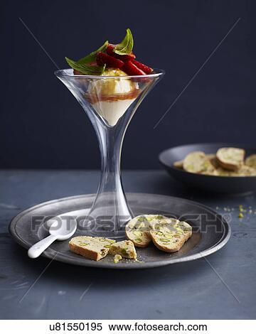 Stock Photography - Ice cream with strawberries and herb garnish and citrus pistachio biscotti. Fotosearch