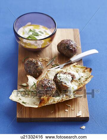 Lebanese meatballs on chopping board with dipping sauce View Large Photo Image Stock Photograph - Lebanese meatballs on chopping board with dipping sauce. Fotosearch
