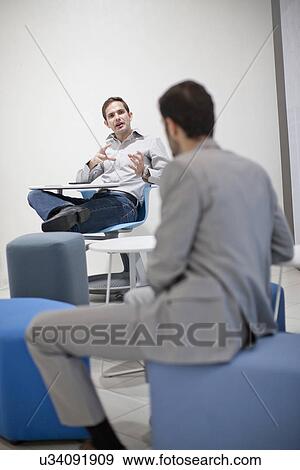 Male colleagues talking in office View Large Photo Image Stock Photo - Male colleagues talking in office. Fotosearch