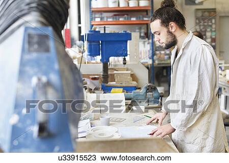 Male potter working in ceramic workshop View Large Photo Image Stock Image - Male potter working in ceramic workshop. Fotosearch