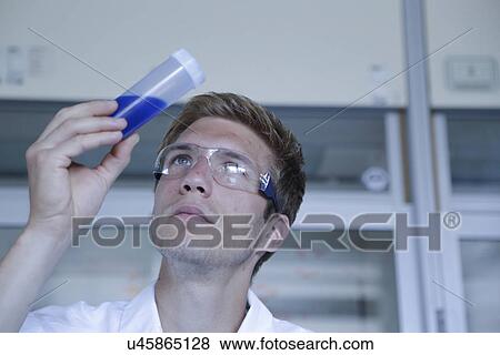 Male scientist looking up at sample in plastic bottle in lab View Large Photo Image Stock Photo - Male scientist looking up at sample in plastic bottle in lab. Fotosearch