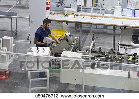 Male worker using machine in paper packaging factory View Large Photo Image Stock Image - Male worker using machine in paper packaging factory. Fotosearch