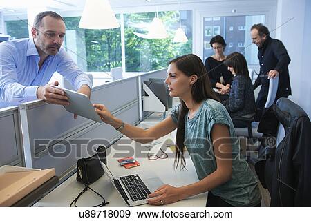 Stock Photo - Man and woman looking at digital tablet. Fotosearch