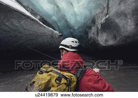 Stock Photo - Man crossing river with rope in ice cave, Vatnajokull Glacier, Vatnajokull National Park, Iceland. Fotosearch