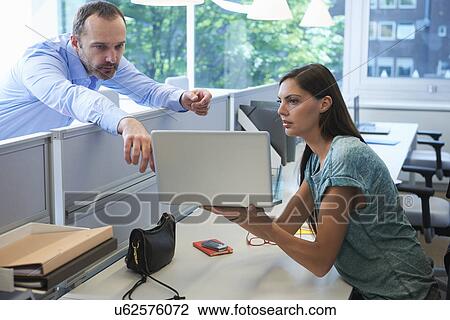 Man leaning over screen partition pointing at laptop computer View Large Photo Image Stock Image - Man leaning over screen partition pointing at laptop computer. Fotosearch