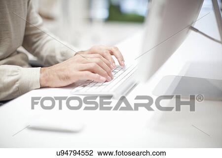 Stock Image - Man using computer keyboard, close up. Fotosearch
