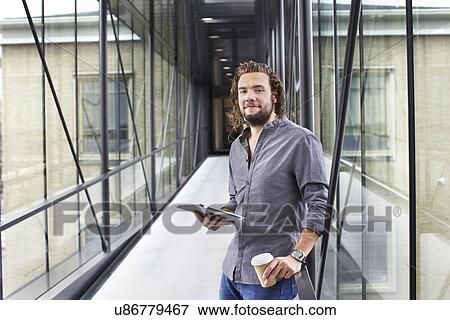Stock Photo - Man with digital tablet on coffee break. Fotosearch
